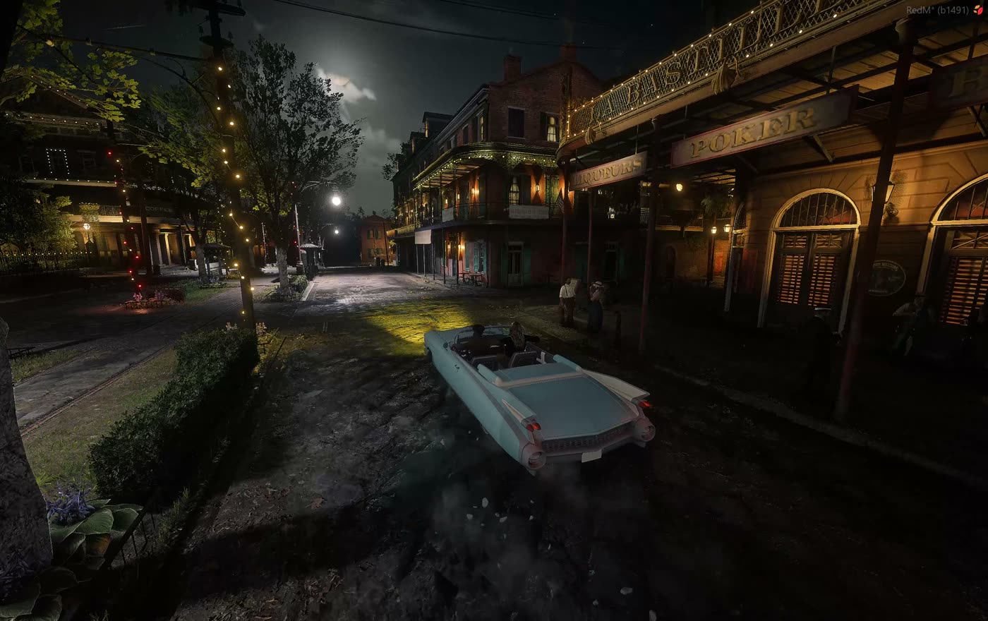 A car driving through town under street lamps