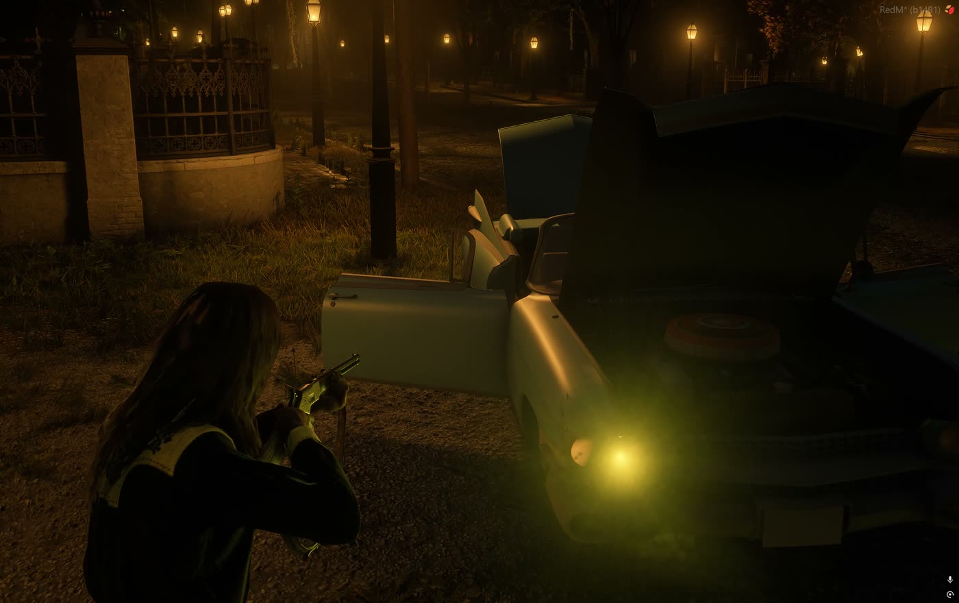 A single headlight lit on a parked car at night