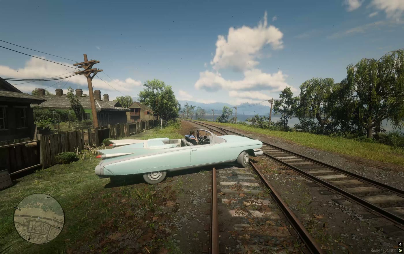 A car crossing the tracks with the lake behind it