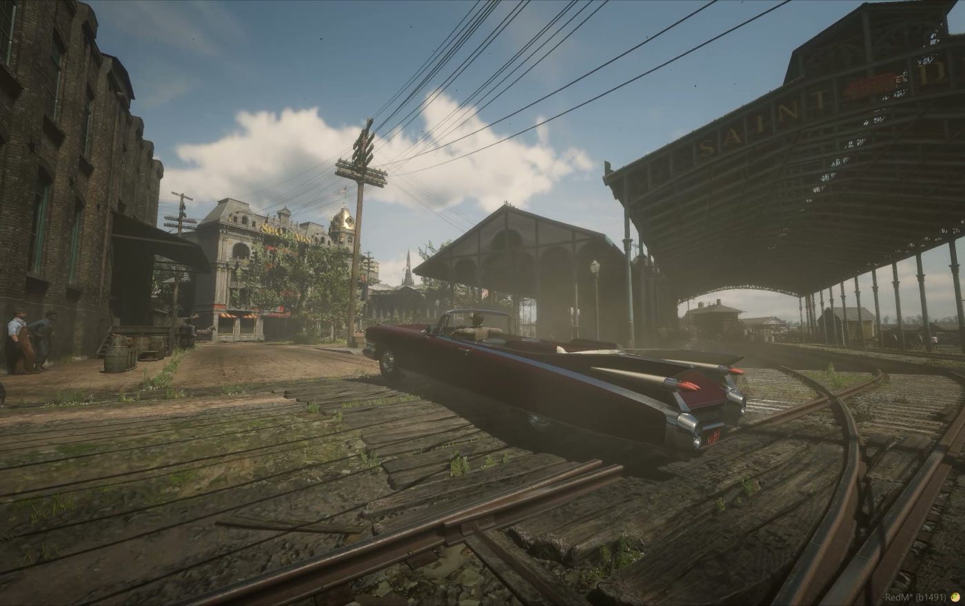 A car crossing the tracks toward the depot