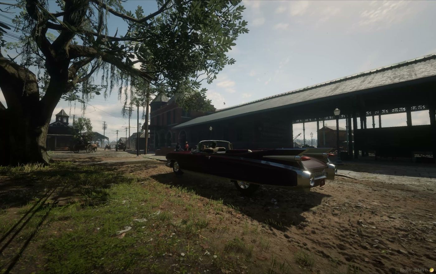 A car parked under a big tree by the station