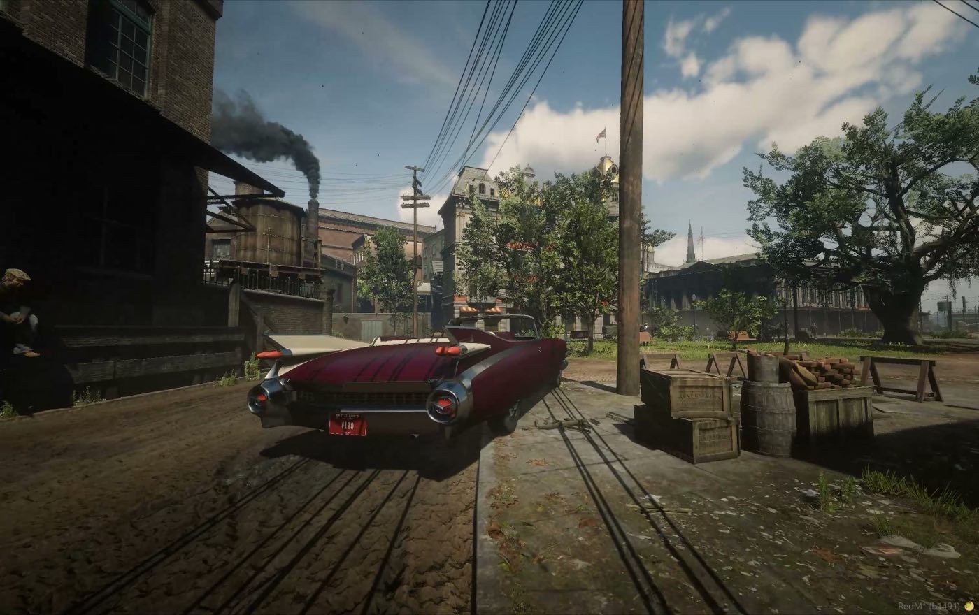 A car on a street corner with the factory chimney behind it